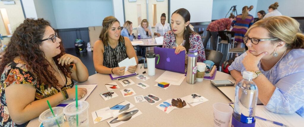 Members of the first CONVEY cohort, from left, Chelsea Forest, Alexis Newman, Sarah Risley, and Tracie Marshburn, work on a group project during the summer institute at the ECU Health Sciences Student Center.