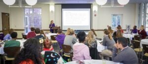 Members of the ECU College of Education Scholars, Education Living-Learning Community students, and other Teacher Education students listen to Lisa Godwin speak about being a first year teacher. 