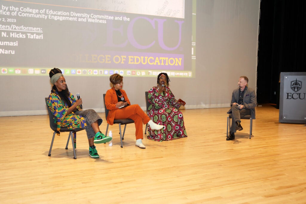 Three hip-hop scholars talk during a panel discussion.