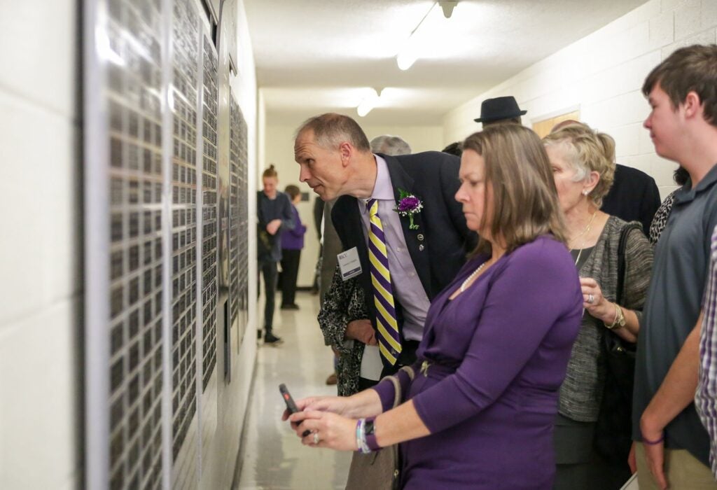 Educators Hall of Fame inductees and their families look at the Educators Hall of Fame Wall inside the Speight Building at the ceremony reception. 