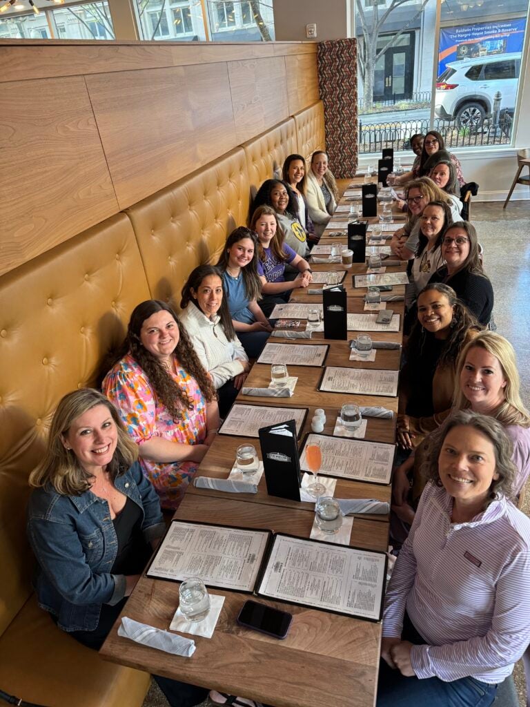 students and faculty sitting at a long dinner table