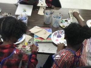 Students from Pines Elementary work on CARE art project