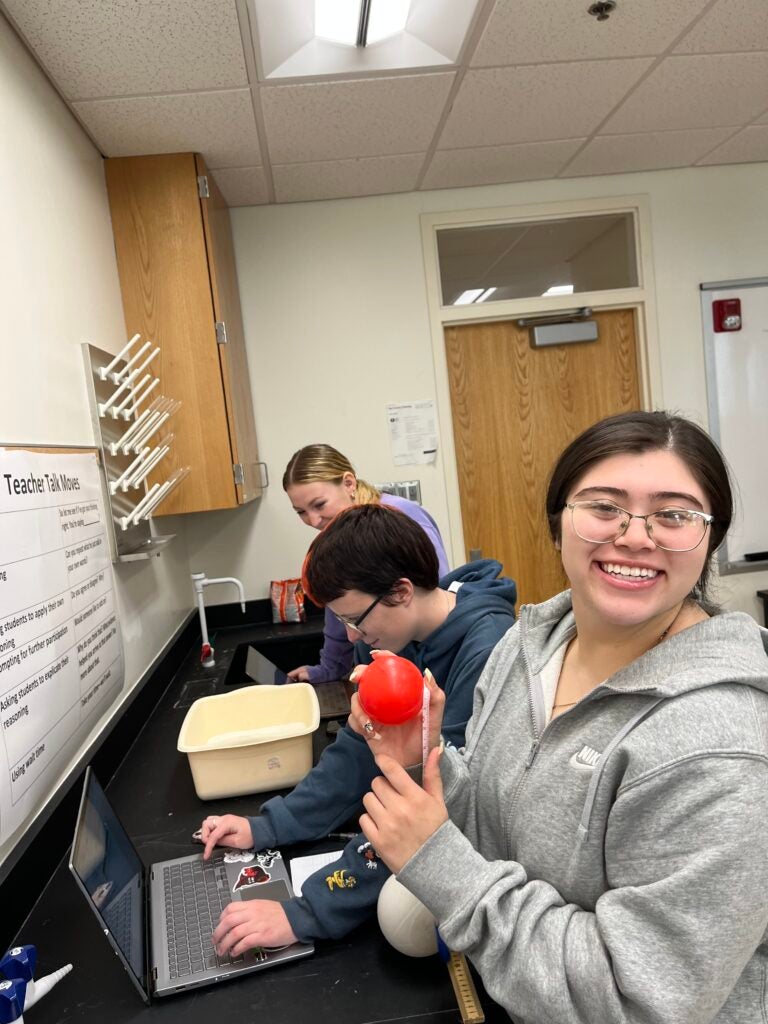 Student holds balloon in science classroom