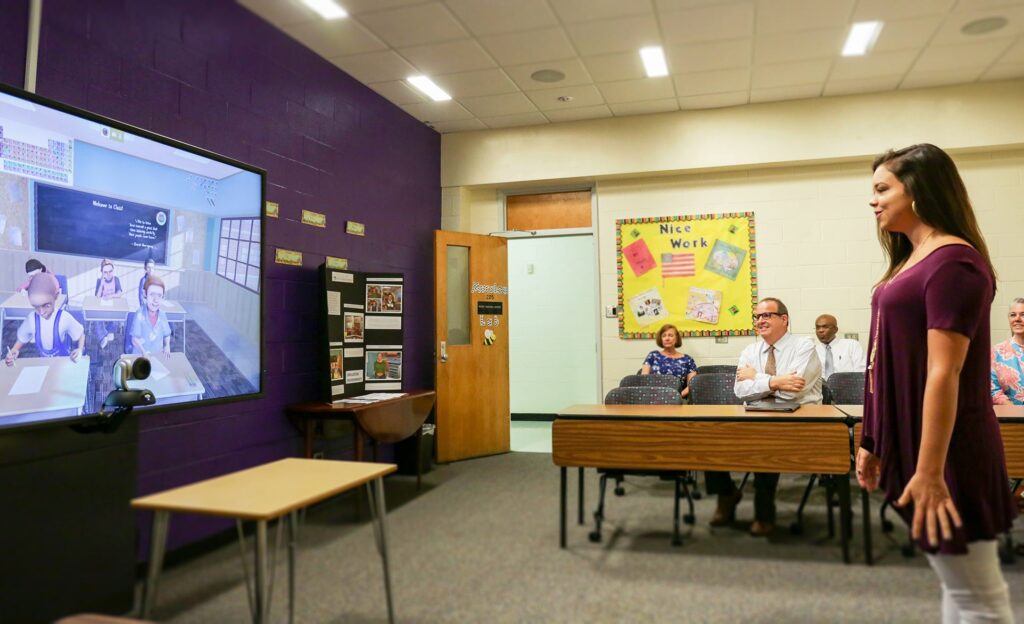 Makenzie Evans, a junior English Education major, demonstrates how to use the Mursion simulation classroom to Dr. Jay Golden, ECU Vice Chancellor of Research, Economic Development and Engagement. 