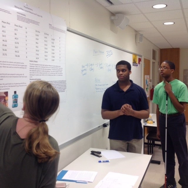 Greene Central High School student Taylor Hill and Pitt County High School students Bishop (BJ) Miles and Lucas Mebane receive feedback on their project 