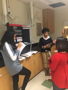 Pitt County high school students Shinjini Misra and Kyra Miles receive feedback on their project from ECU student judges.