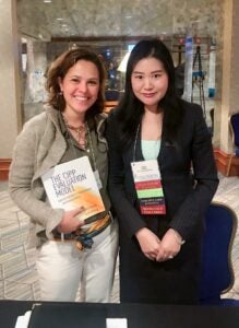 Dr. Guili Zhang, right, with a colleague that purchased Zhang's book during a book signing at the American Evaluation Association annual conference in Washington, D.C., Nov. 6-11.