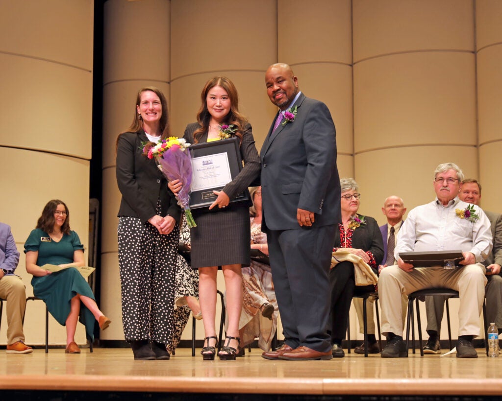 Zhang poses for a photo with her Educators Hall of Fame award