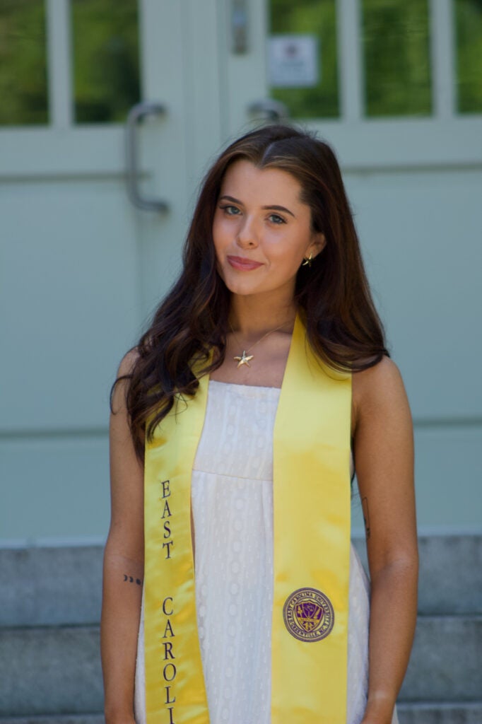 female graduate standing in front of doors