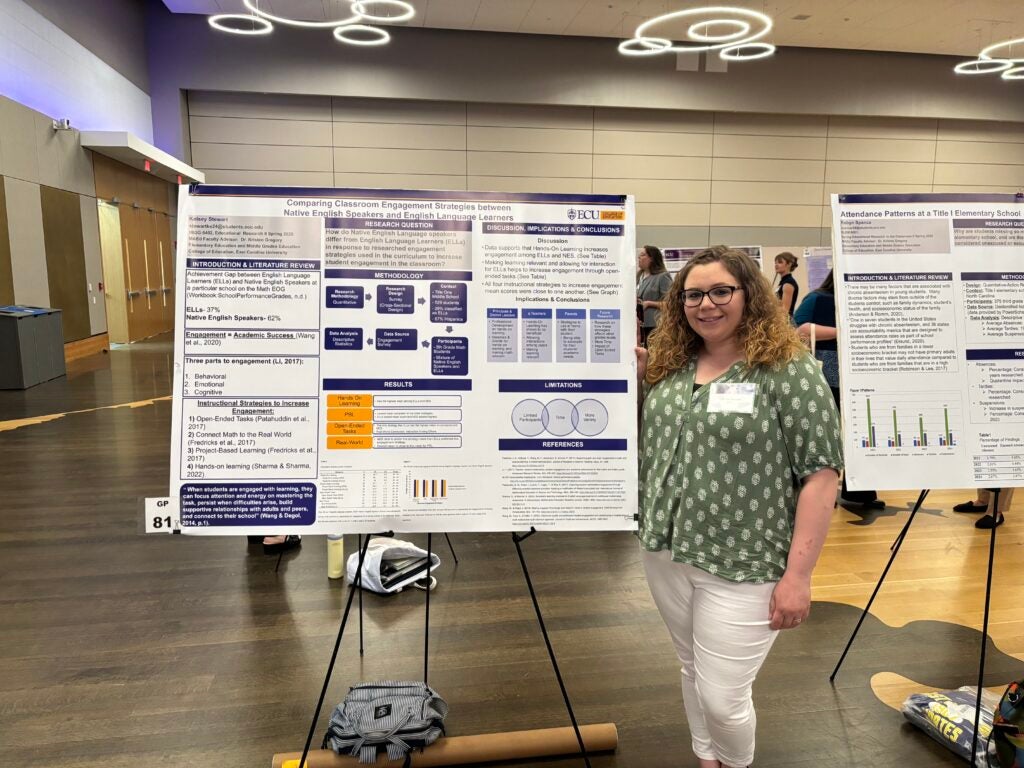 female student standing beside a poster presentation