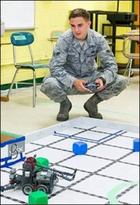 USAF airman first class Eagan Nadeau pilots one of the student robots.