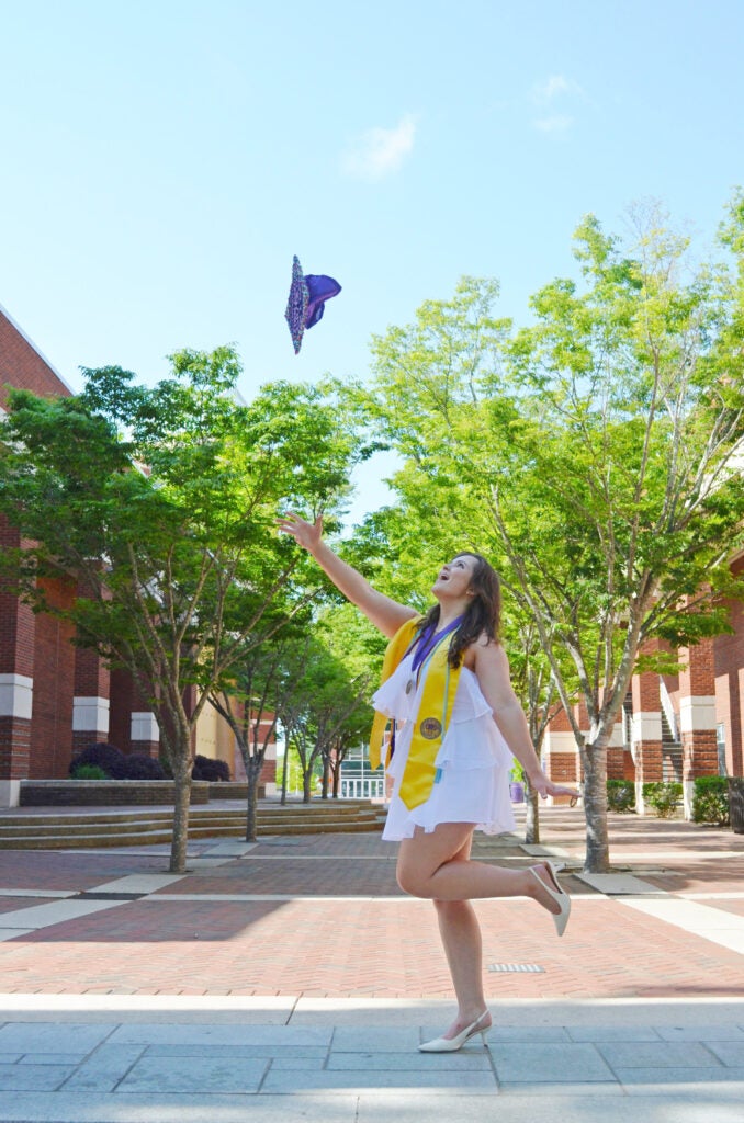 female graduate throwing her grad cap in the air