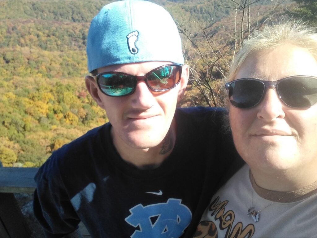 man and woman standing stand by side in front of mountain view