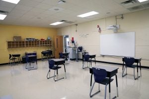 Desks spaced six feet apart in a classroom at the ECU Community School